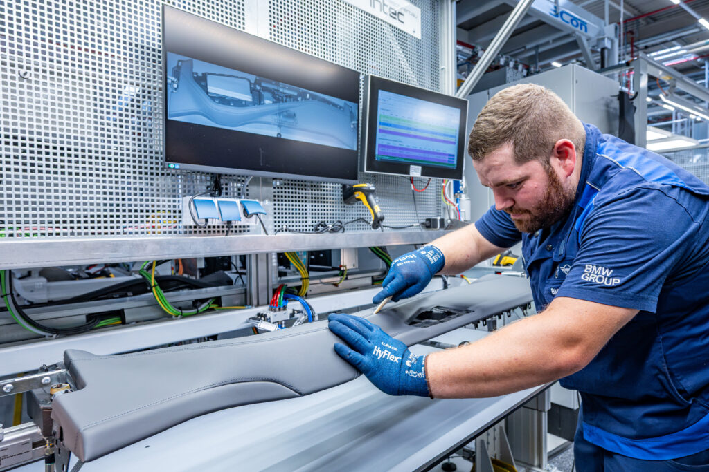 Técnico de BMW Group trabajando en acabados interiores del nuevo BMW Serie 7 en la Planta Dingolfing, donde se combinan procesos artesanales, herramientas digitales y alta tecnología.