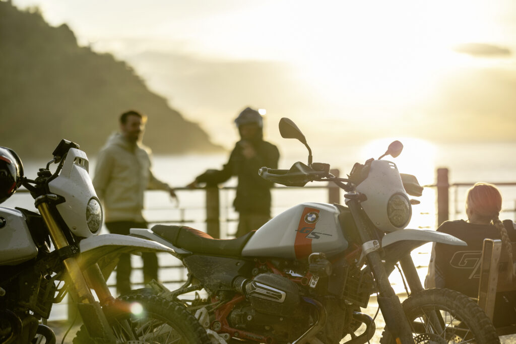 BMW R 12 G/S junto al mar al atardecer, modelo incluido en las actualizaciones BMW Motorrad 2027 con nuevas variantes Option 719 y color Frozen Brooklyn Grey metallic.