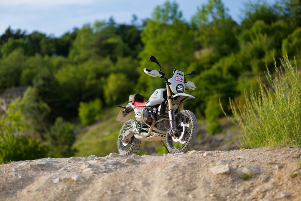 BMW R 12 G/S GS Trophy Competition Bike 2026 sobre un camino off-road, diseñada para aventuras fuera de carretera en el International GS Trophy de Rumania.