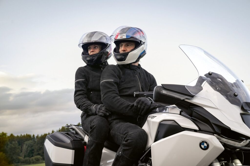 Dos motociclistas usando ropa y equipamiento BMW Motorrad 2026 en una moto touring, destacando seguridad, comodidad y estilo para viajar en moto.